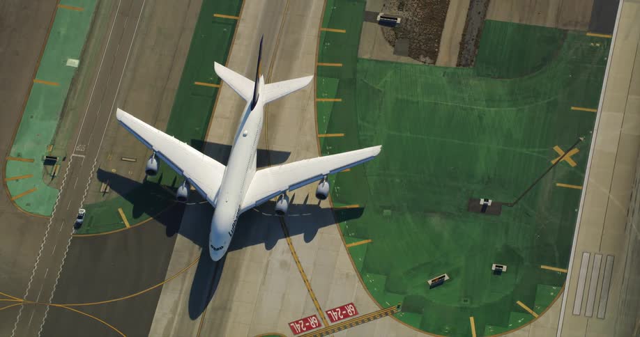 Aerial view of a commercial airplane waiting on the runway in the airport