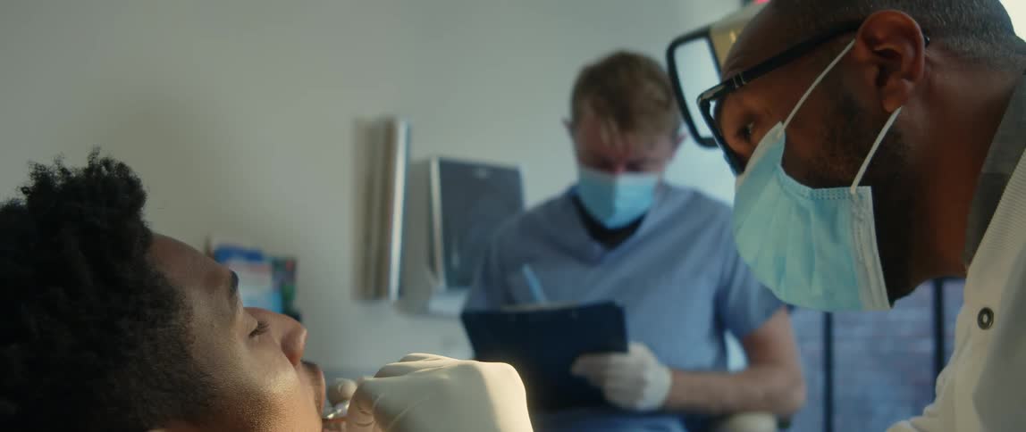 A dentist examining a patients teeth in a dental office
