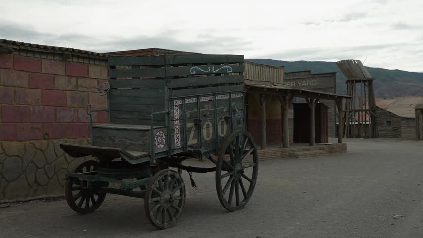 An old wagon is abandoned on the road in a ghost town