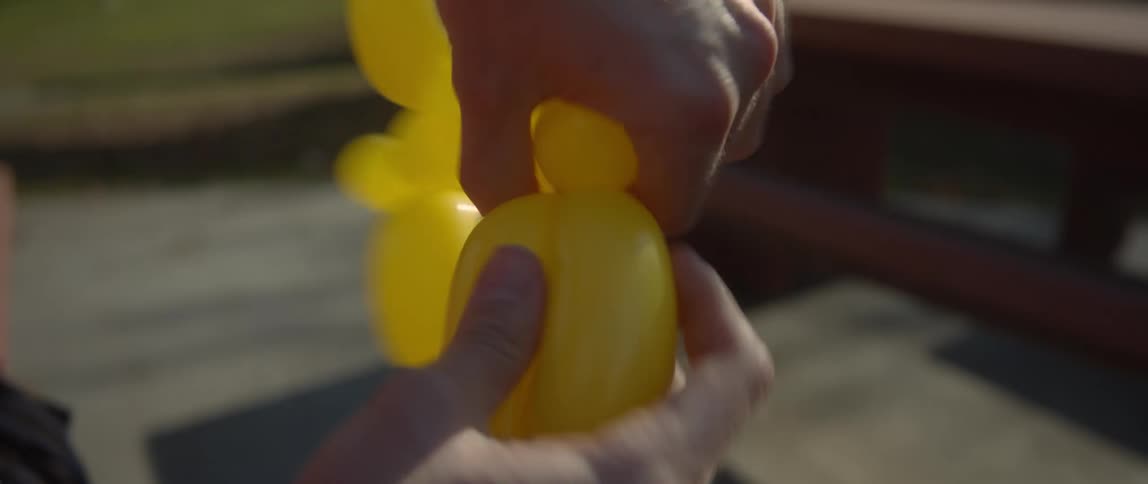 A man makes a balloon animal outside