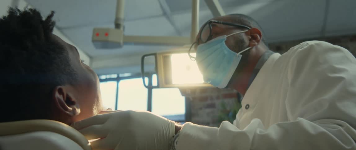 A dentist looks into a patients mouth