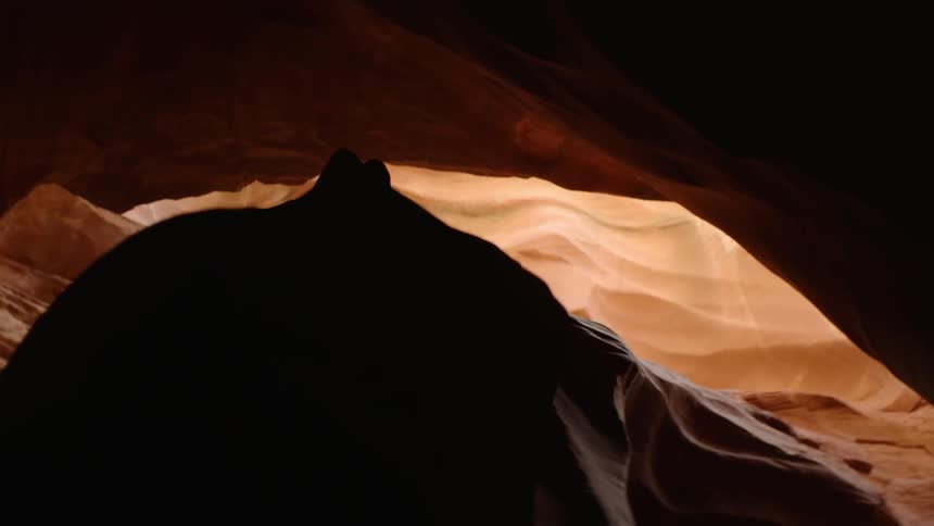 Sunlight enters a cave in the desert through an opening in the ceiling