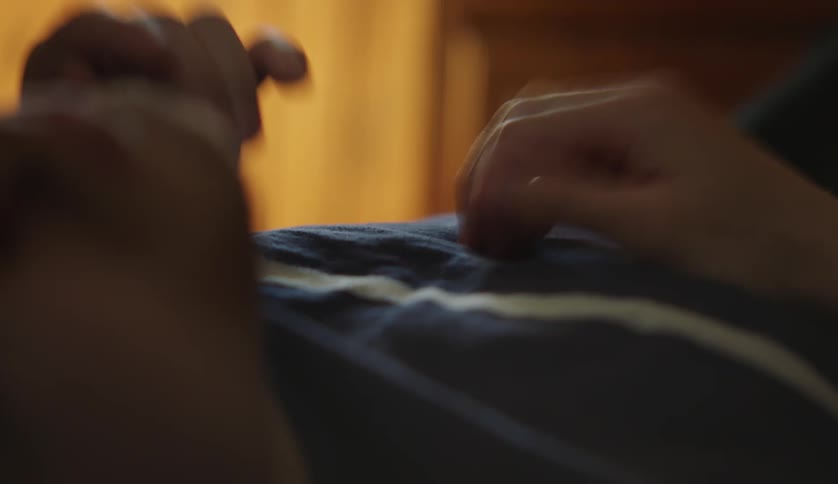 Man lies on his back tapping his hands against his chest