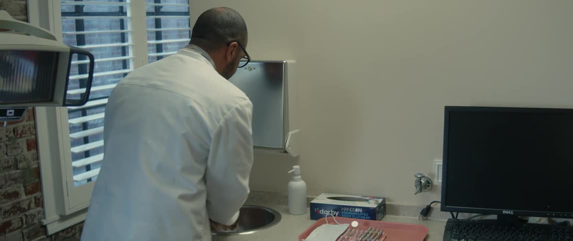 A male dentist washing his hands in a dental office