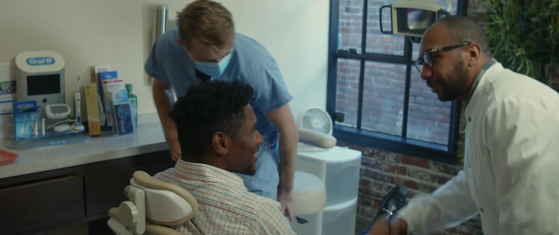 A young man is at the dentist and is talking to the doctor