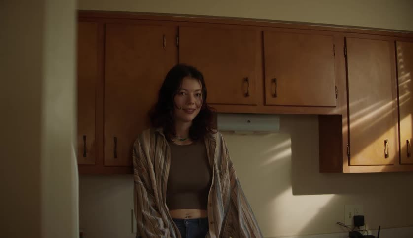 A young white woman is standing inside of her home