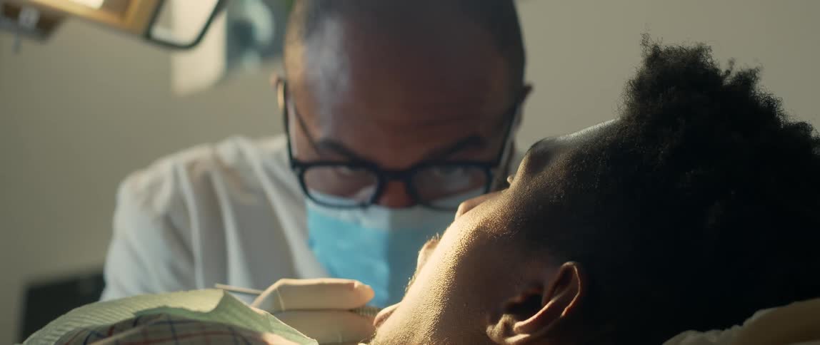 A dentist examining and cleaning a patients teeth