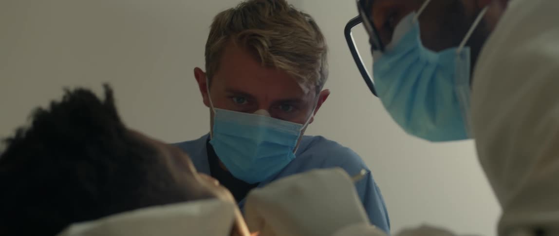 A young patient is at the clinic and the doctor is working on his teeth