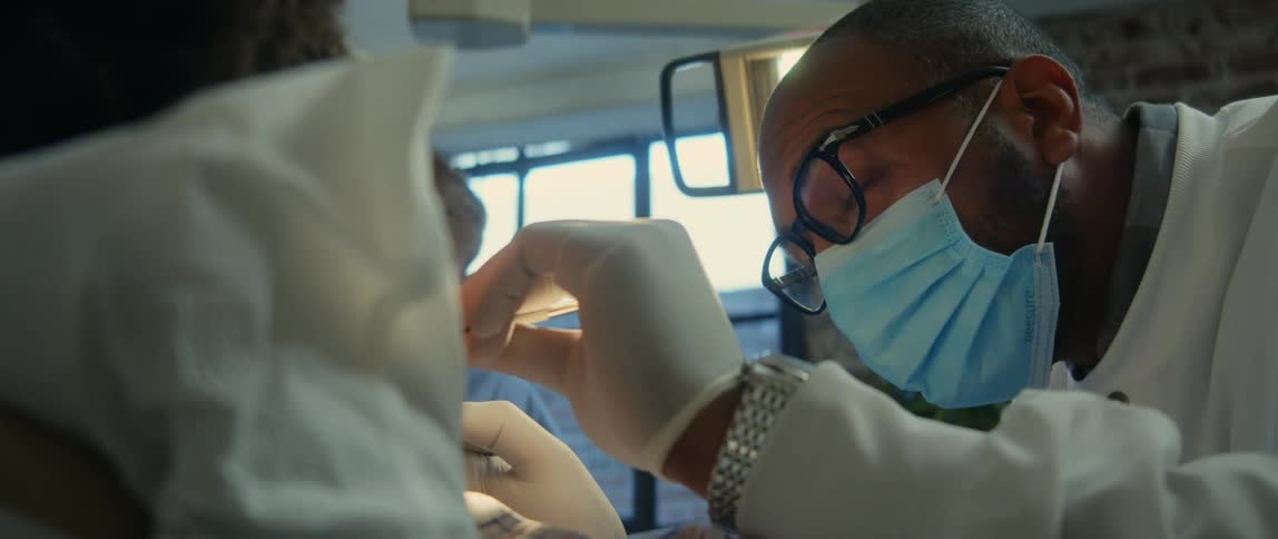 A young patient is at the dentist and the doctor is working on his teeth