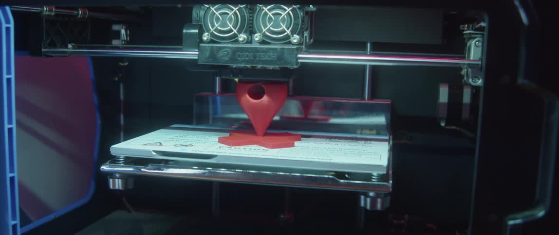 An additive manufacturing machine is creating a three dimensional object