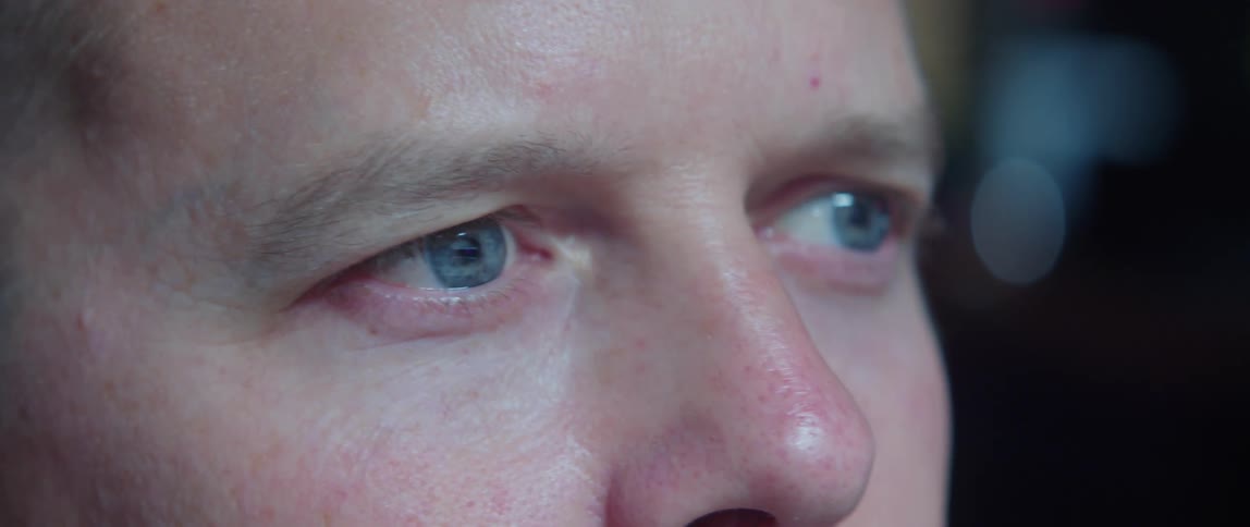 Close up of mans face with blue eyes looking around