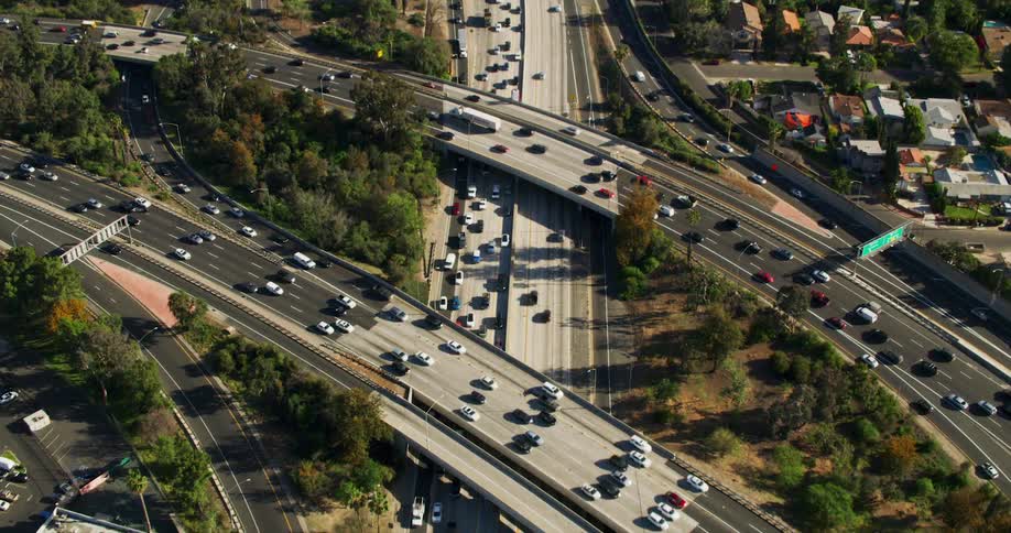 There are a bunch of cars that are driving down the highway