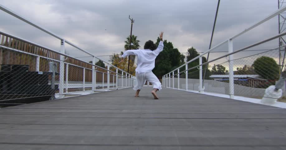 A woman is dancing on the boardwalk