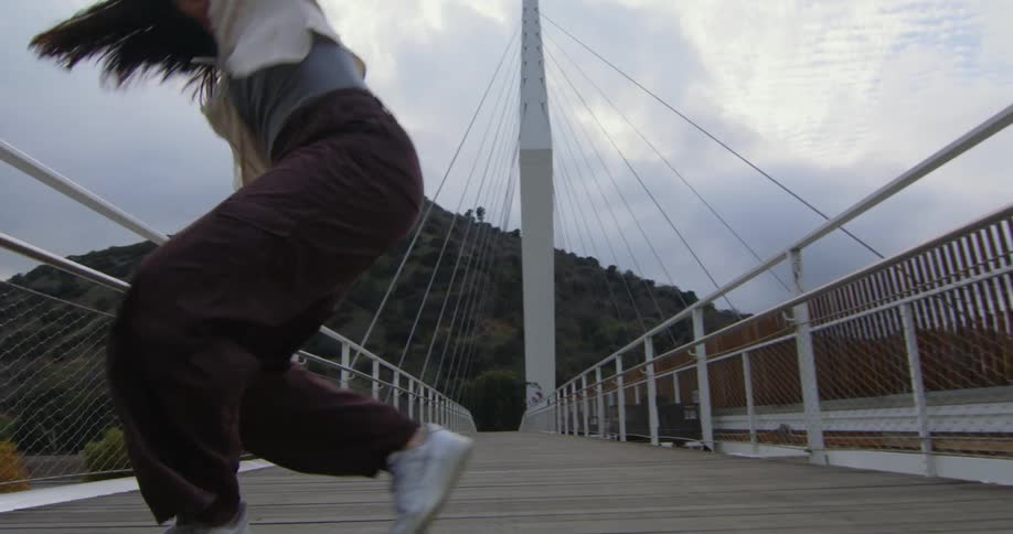 A woman is dancing on a bridge during the spring