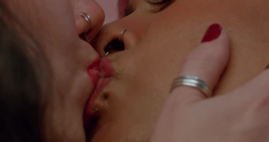 Female couple kiss repeatedly while one holds the others cheek
