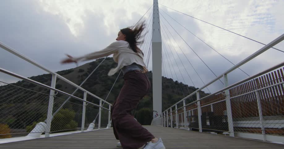 A woman is dancing on the boardwalk