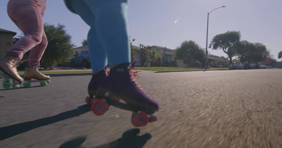 Two friends are rollerblading outside in there neighborhood