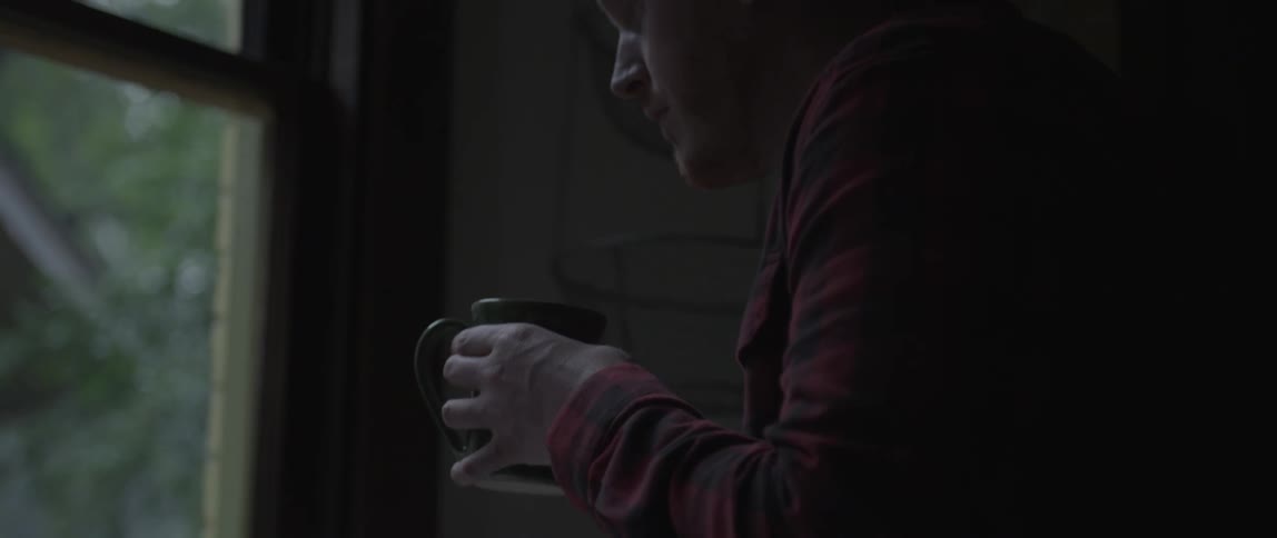 A man pours water from a faucet into his mug