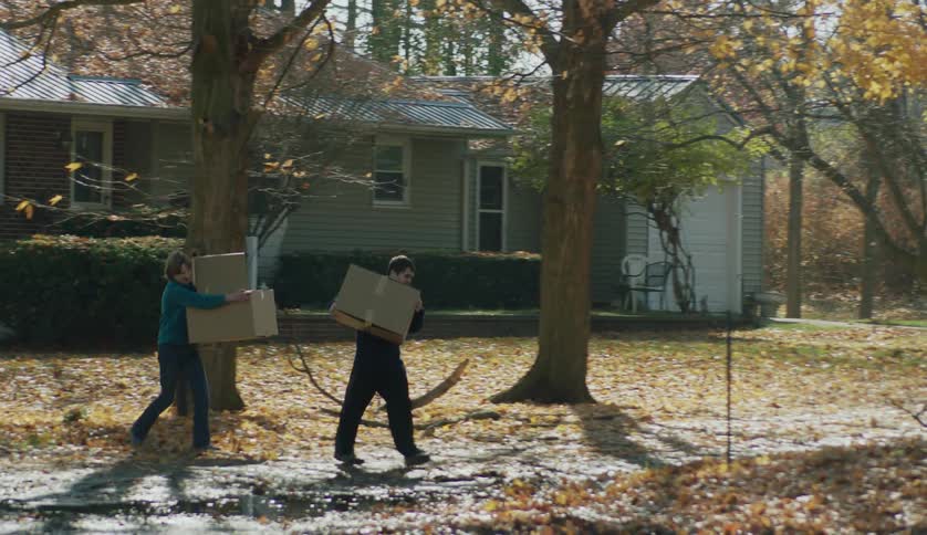 A man and woman carrying out boxes