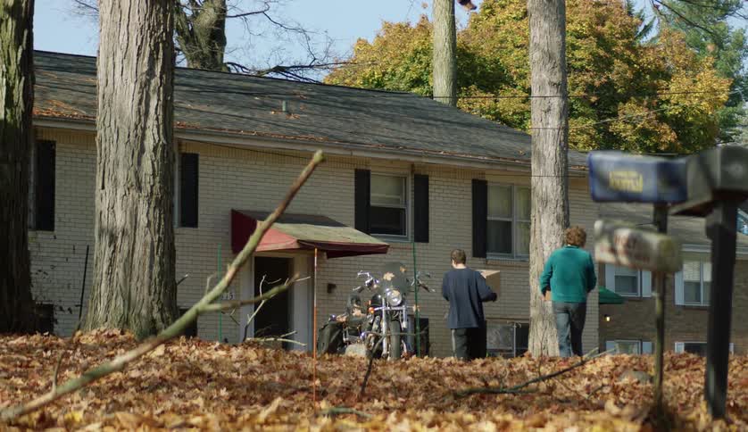 People are walking outside into there home in the day time