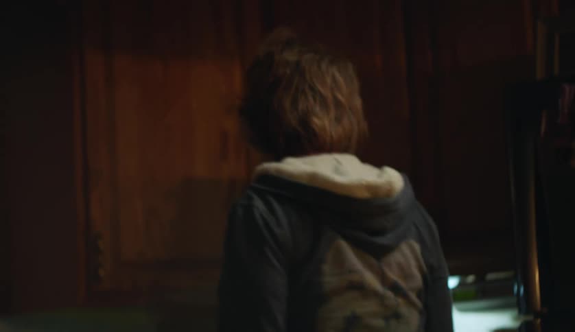 An older woman is talking on the phone to someone in her house