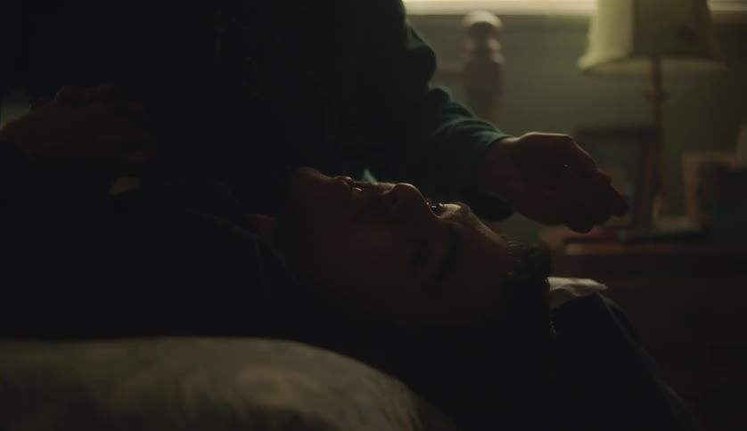 A male is laying on his bed in his bedroom