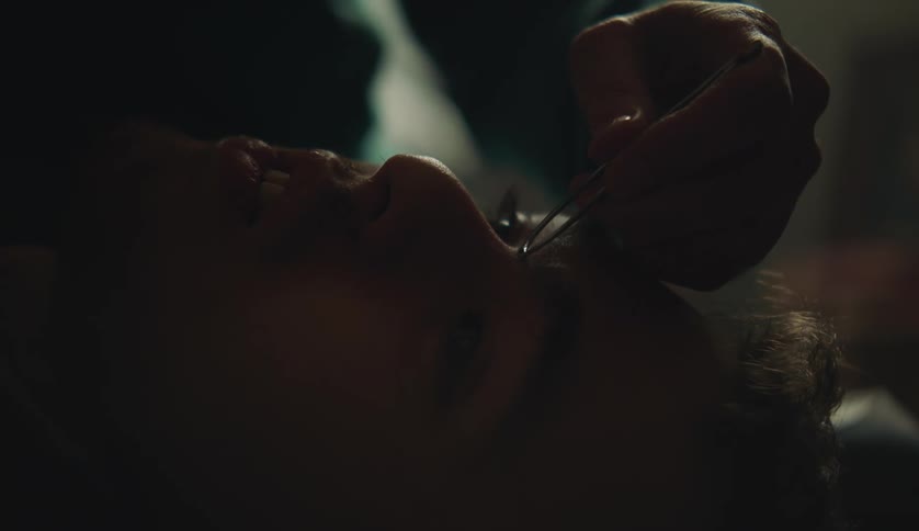 A person is having his eyebrows plucked