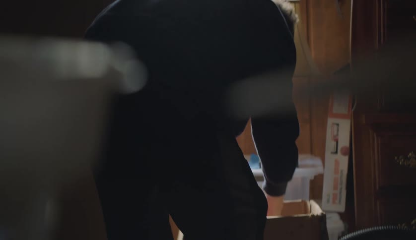 Young man packing books on a cardboard box in a room at home