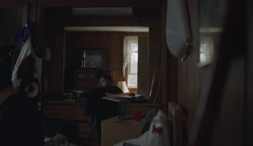 A teenage boy is inside of his home in the middle of the day