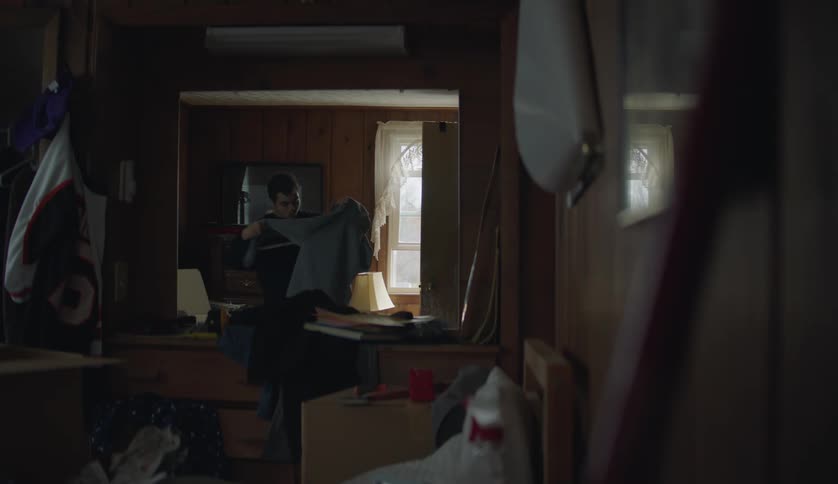 A boy folds his clothes at home