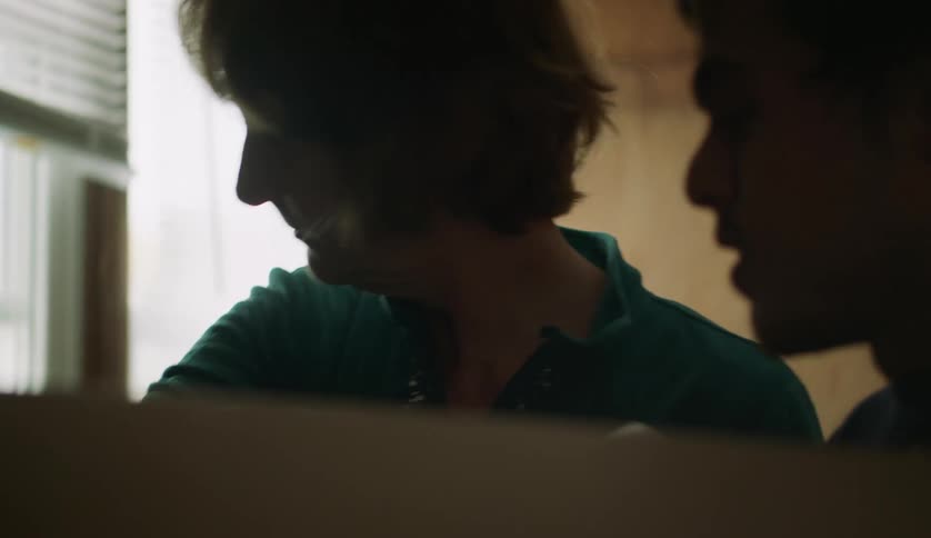 Woman shows man a flashlight before putting it into the box the man is holding