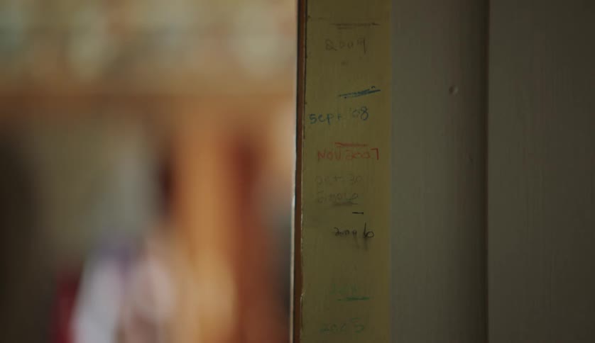 Close up of handwritten markings on a doorframe while a person walks by