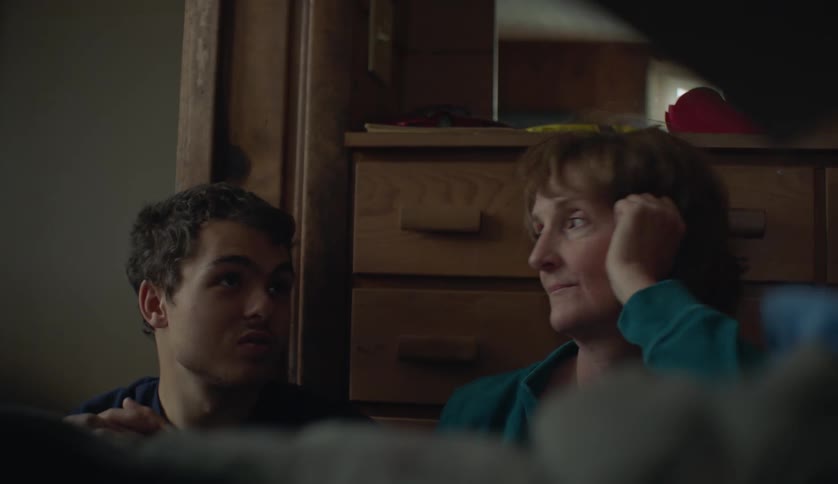 A woman laughs with a teenager