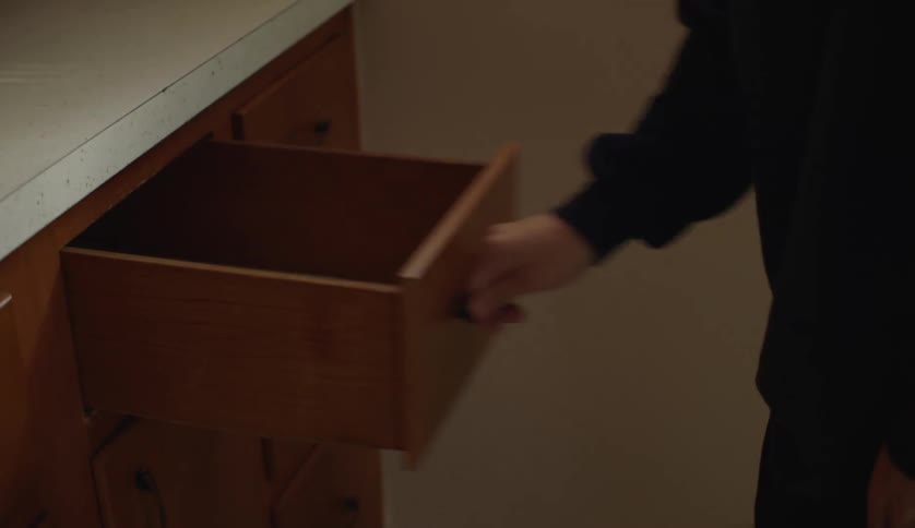 A person violently opening an empty kitchen drawer