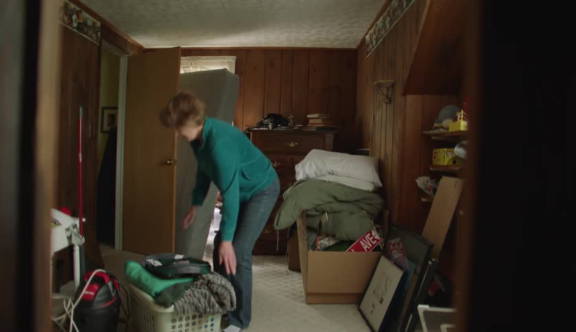 Family moving boxes and baskets full of laundry from one room into the other