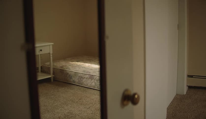 A mattress and nightstand in an empty room