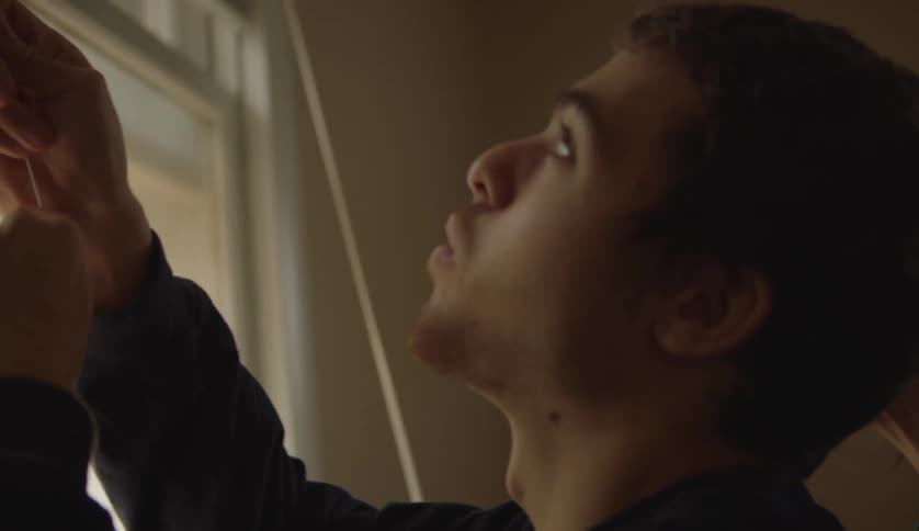 Mother and son are opening the window curtains together