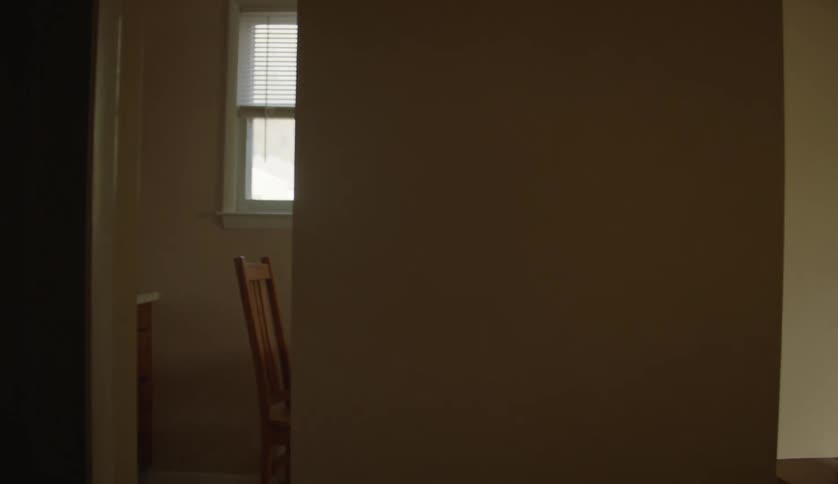 There is a person carrying something inside of her home