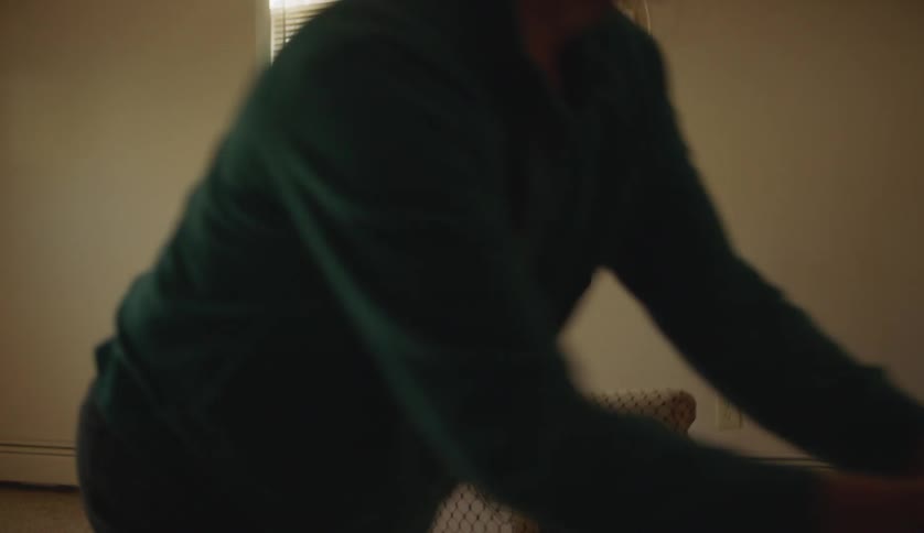 Young man with special needs playing ball at home while sitting on a chair