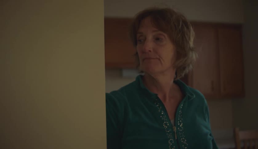 A woman is standing inside her house alone