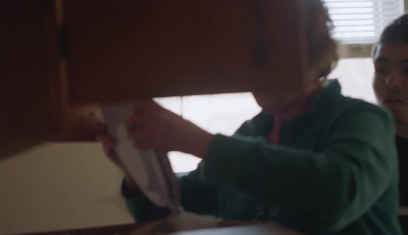 Two people are unpacking boxes in their kitchen