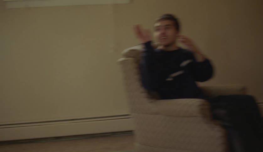 A young teenage boy is playing with a basketball inside of his home