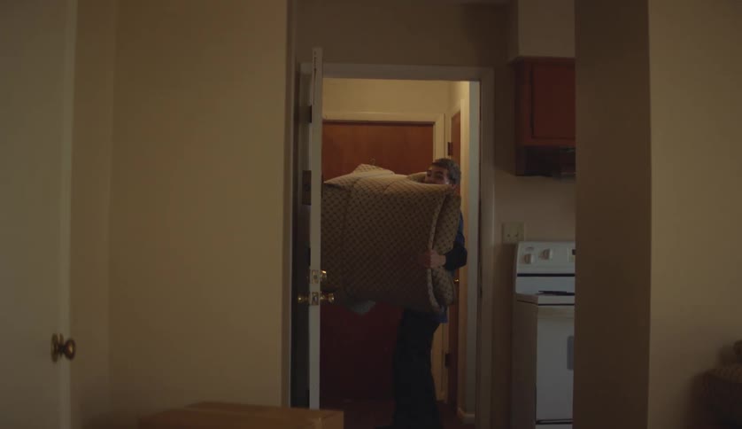 A male is carrying a chair into his room