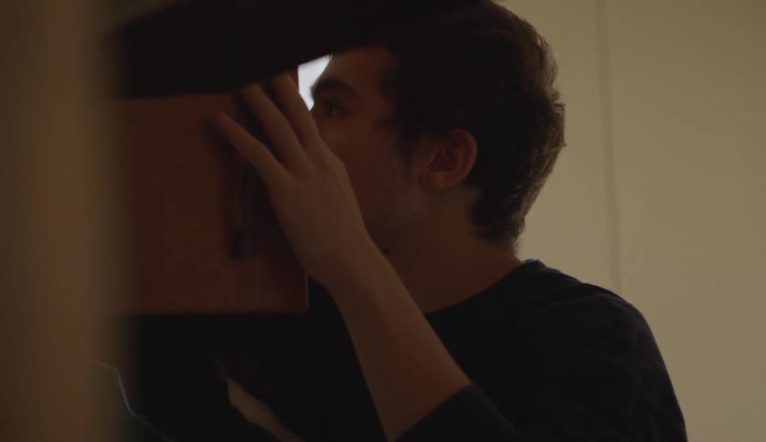 Mother and son unpacking dishes and glasses into kitchen cabinet