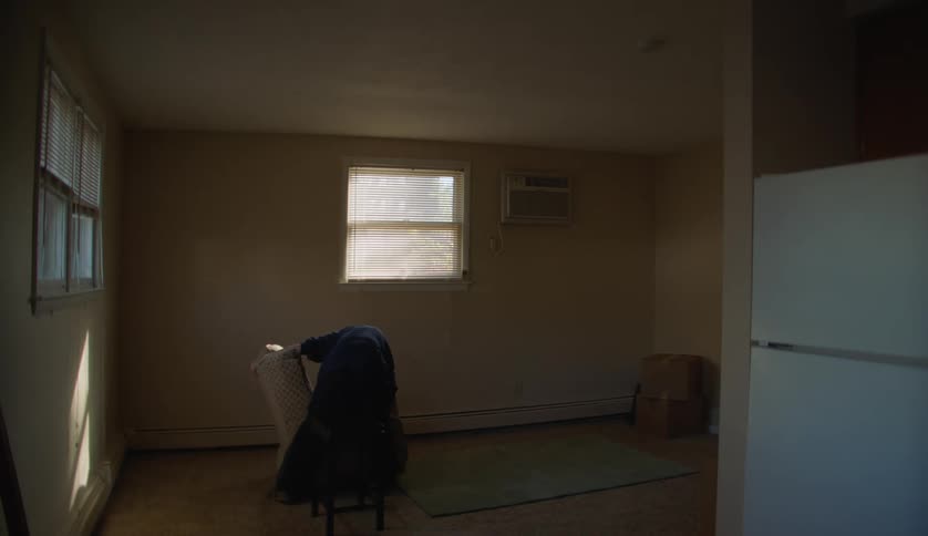 A boy is placing furniture in the room