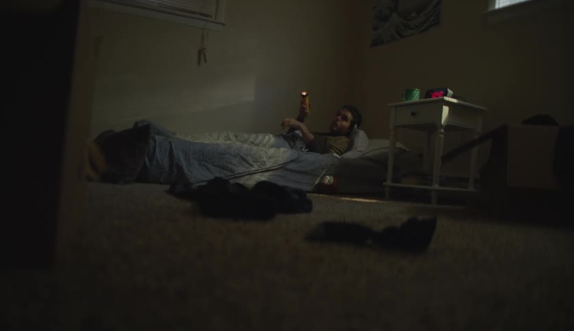 A male is laying down in his room