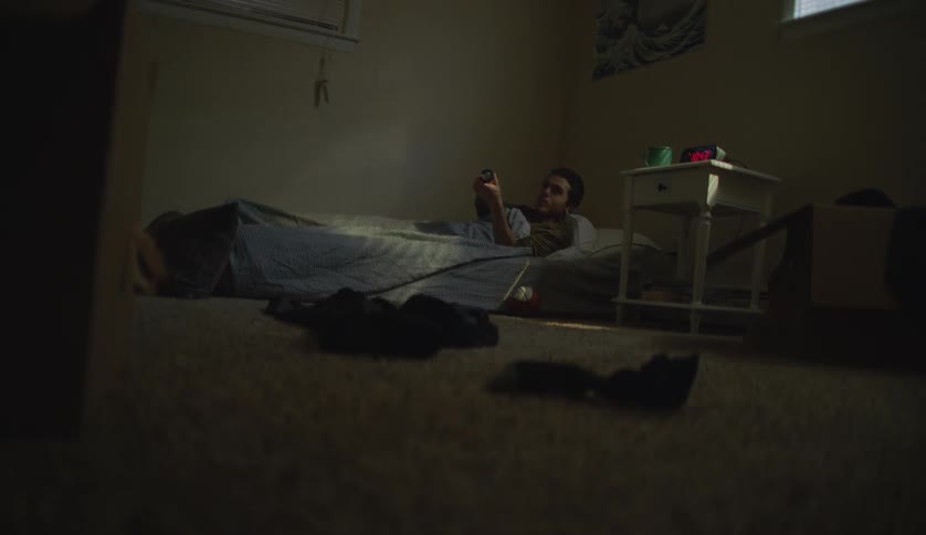 Man lying in bed tries to turn on flashlight in his room