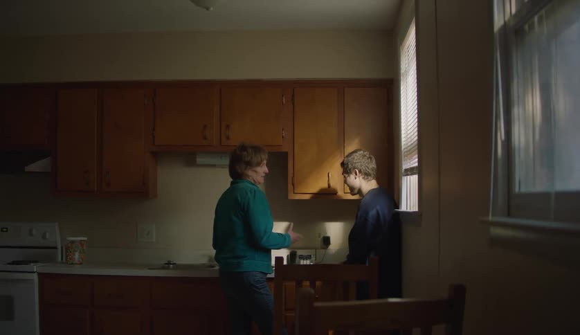 Grandmother speaks to her grandson in the kitchen at home