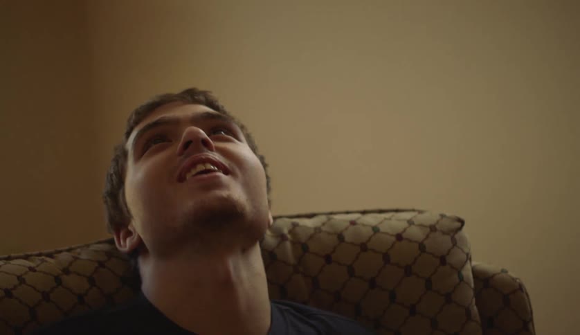 Young man with special needs sitting on a spinning chair in the living room