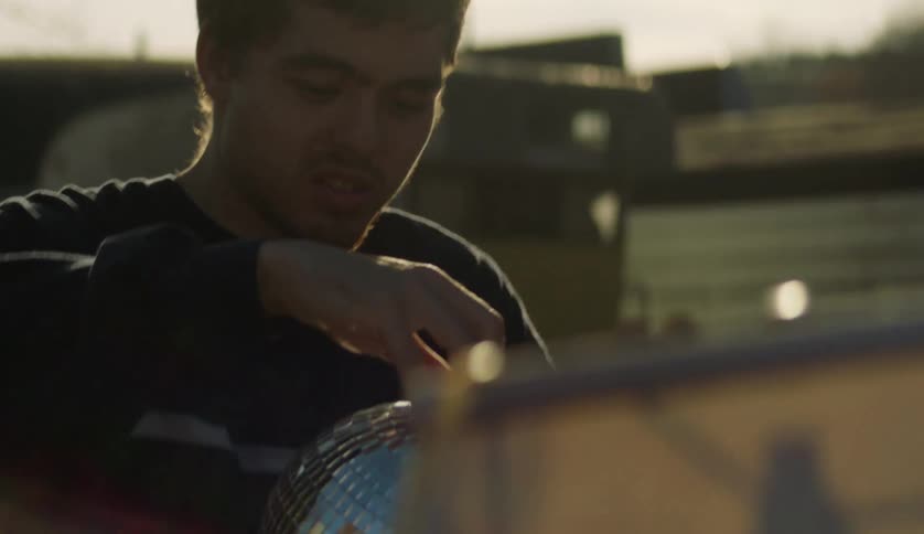 A man is handed a large mirror disco ball